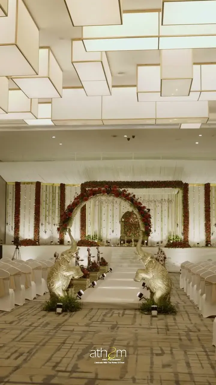 Indoor Ganesh wedding stage with floral aisle and warm lighting