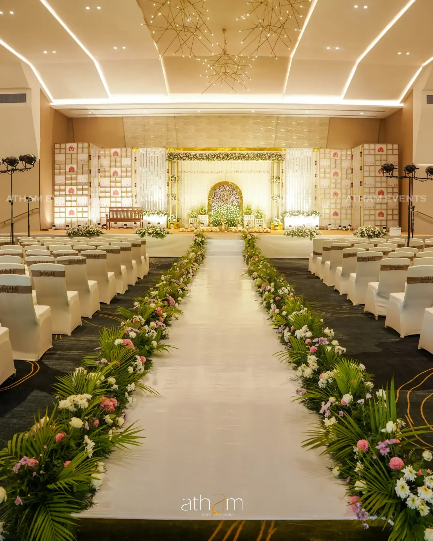 Luxury ballroom wedding stage with illuminated aisle and floral décor