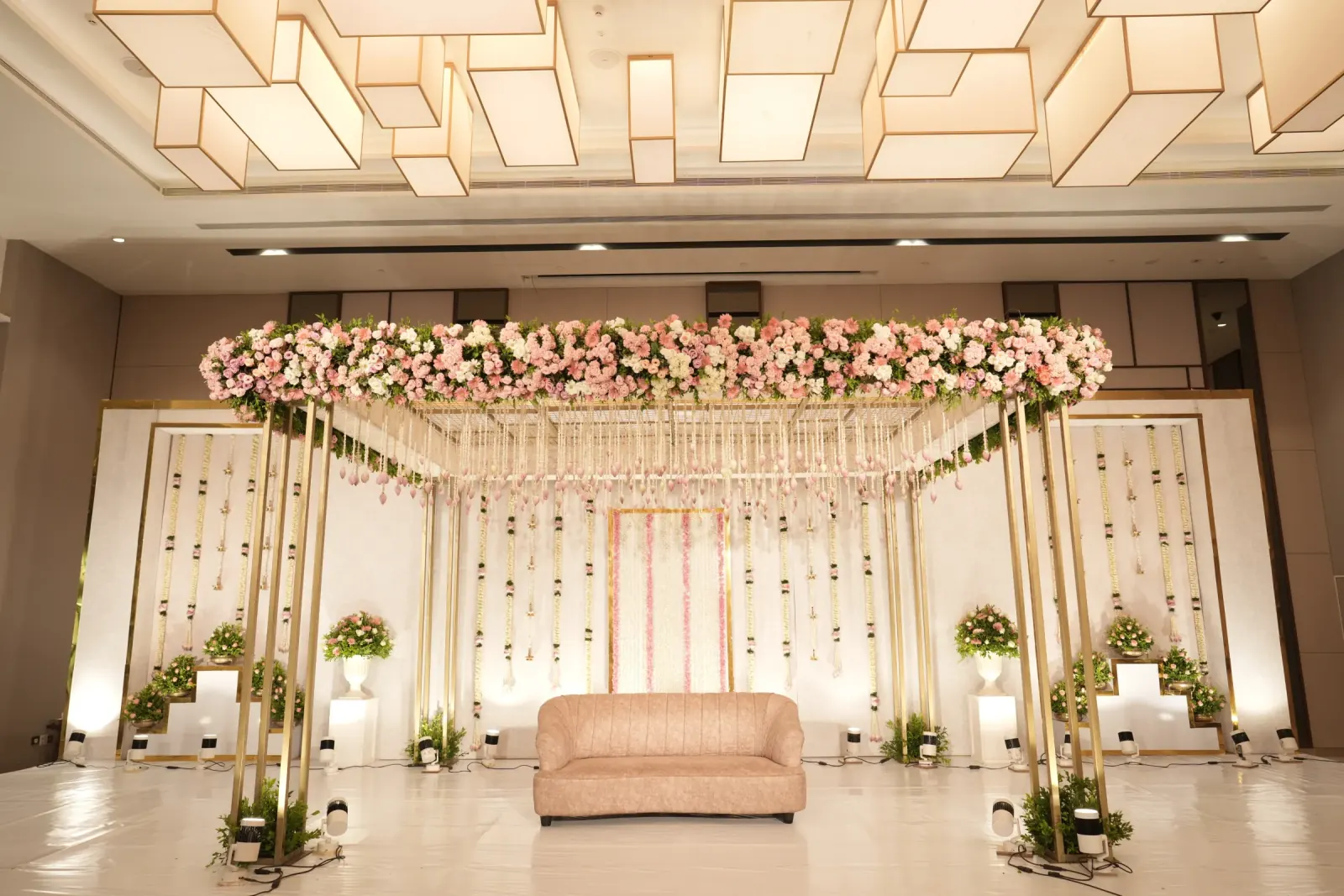 Blush pink floral ballroom stage with modern geometric ceiling lights
