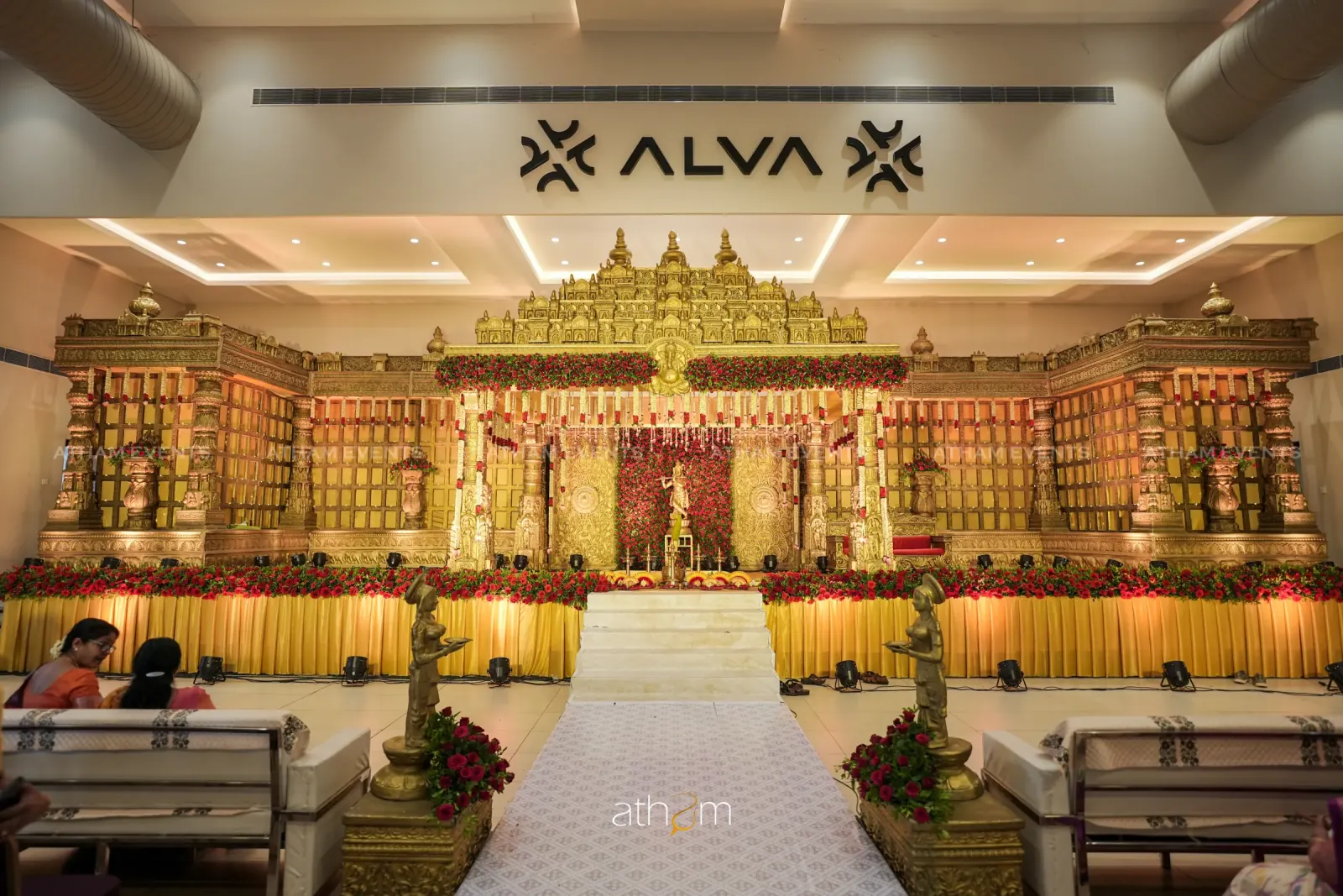 Grand gold palace wedding stage with red roses and temple architecture