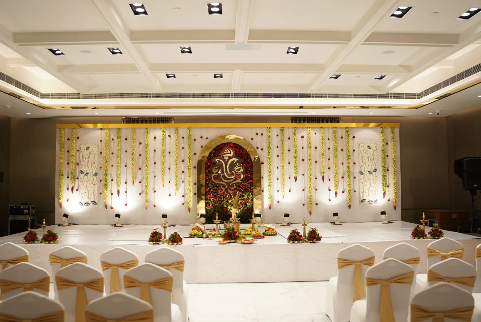 Minimal Ganesh floral wedding stage with hanging jasmine garlands
