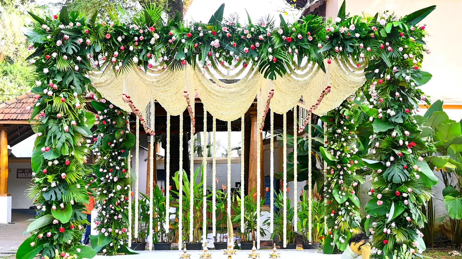 Outdoor tropical floral wedding mandap with jasmine garlands