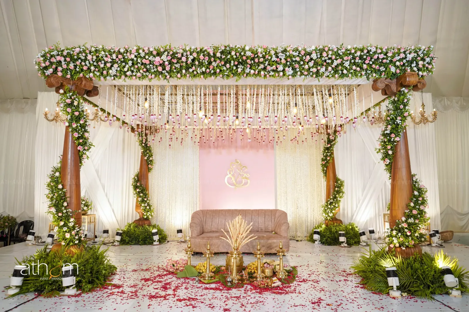 Pastel pink floral wooden mandap with jasmine canopy and greenery