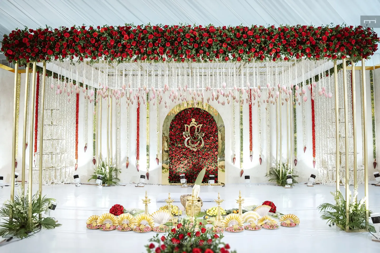 Red rose Ganesh canopy stage with white jasmine and gold details