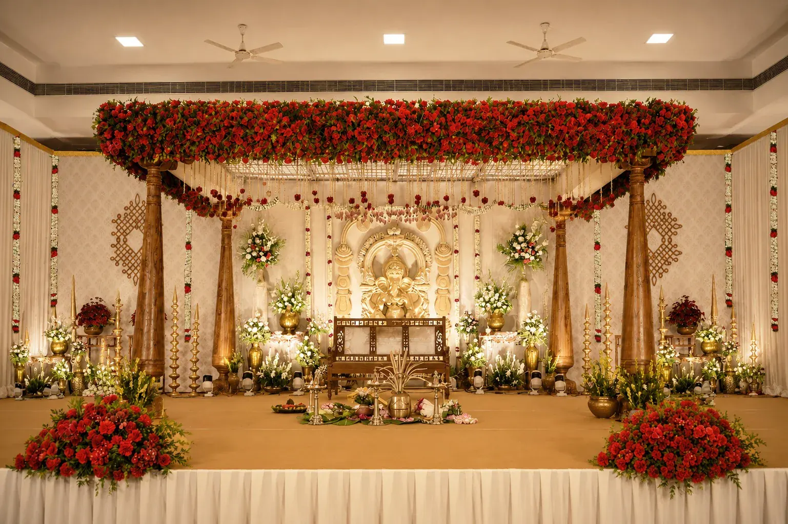 Red rose wooden Ganesh wedding stage with traditional brass lamps